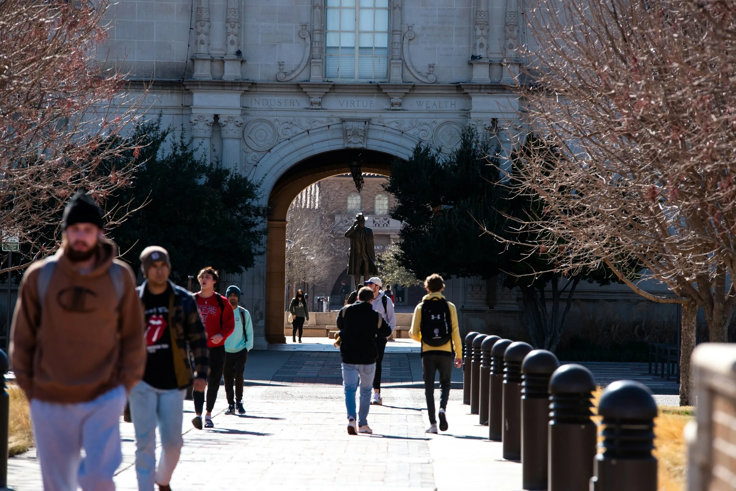 Students walking through a historic university campus archway